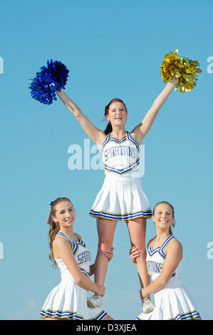 Kaukasische Cheerleader posieren zusammen Stockfoto