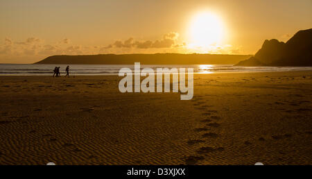 Menschen zu Fuß am Strand im Sonnenuntergang, Footprints, Three Cliffs Bay, Gower Halbinsel, Wales, Vereinigtes Königreich, Europa Stockfoto