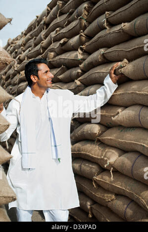 Mann, Blick auf Stapel Säcke Weizen in einem Lagerhaus Anaj Mandi, Kapur, Gurgaon, Haryana, Indien Stockfoto