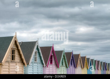 Mersea, Essex. Reihe von bunten traditionellen Strandhütte Stockfoto