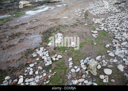 Abrieb und Verschleiß an der Welle schneiden Plattform wie Kieselsteine abgerundet sind und durch die Bewegung des Wassers, Watchet, Somerset, England transportiert, Großbritannien Stockfoto