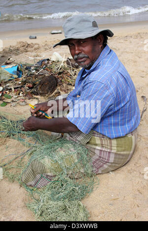 Sri Lankan Mann ausbessern Fischernetze Stockfoto