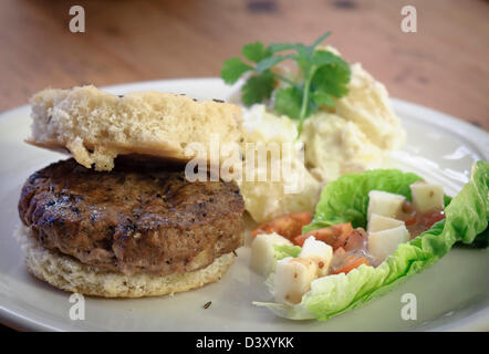 Lamm-Burger auf Foccaia Brot mit Kartoffelsalat und Salat. Stockfoto