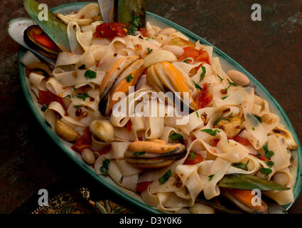 Ein Tagliatelle Pasta-Teller mit Cannelini Bohnen, grüne Muscheln, Knoblauch und Petersilie. Stockfoto