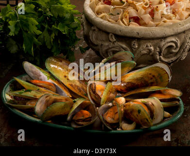 Eine grüne Muschel-Platte begleitet von Tagliatelle Pasta und italienische, flache Petersilie. Stockfoto