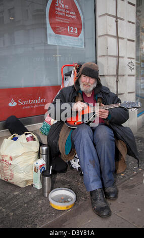 Alan Bent ältere Busker außerhalb der Santander Bank zeigt Angebote, Incentives  Menschen und die Straßen und Geschäfte von Manchester, Lancashire, England, Großbritannien Stockfoto