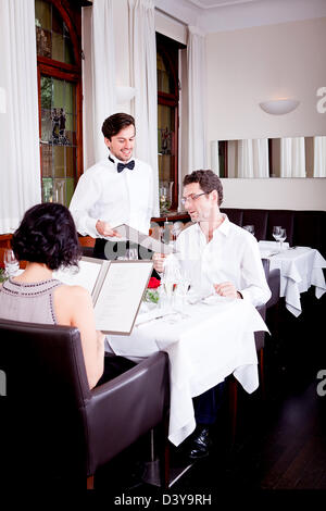 Mann und Frau im Restaurant Kellner bringen Karte und bestellen Essen Stockfoto