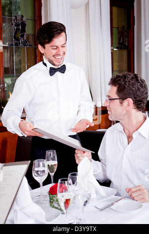 Mann und Frau im Restaurant Kellner bringen Karte und bestellen Essen Stockfoto