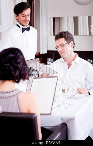 Mann und Frau im Restaurant Kellner bringen Karte und bestellen Essen Stockfoto