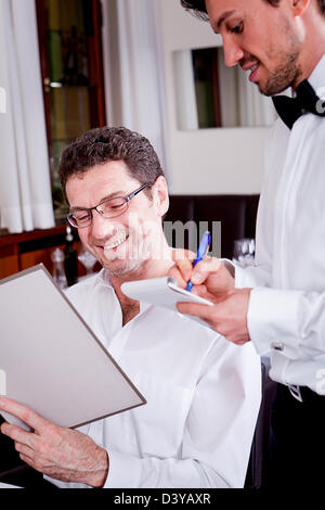 Mann und Frau im Restaurant Kellner bringen Karte und bestellen Essen Stockfoto