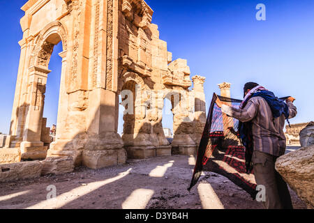 Seide Souvenirs Verkäufer warten auf Touristen in den Ruinen der monumentalen Bogen von Palmyra. Palmyra, Syrien Stockfoto