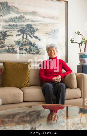 Chinesische Frau sitzend auf sofa Stockfoto