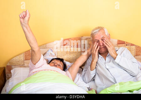 Älteres Paar im Bett Strecken und aufwachen. Stockfoto