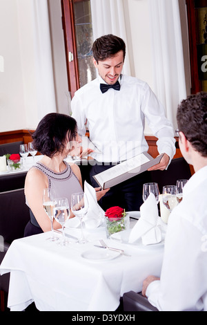Mann und Frau im Restaurant Kellner bringen Karte und bestellen Essen Stockfoto