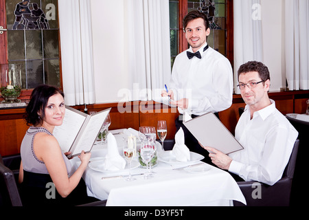 Mann und Frau im Restaurant Kellner bringen Karte und bestellen Essen Stockfoto