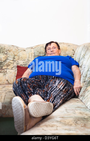 Porträt von adipösen Seniorin auf Sofa. Stockfoto
