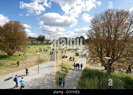 Thomas Tallis Schule, Greenwich, Großbritannien. Architekt: John McAslan & Partner, 2012. Grüne Gartenanlage mit Gehweg Stockfoto