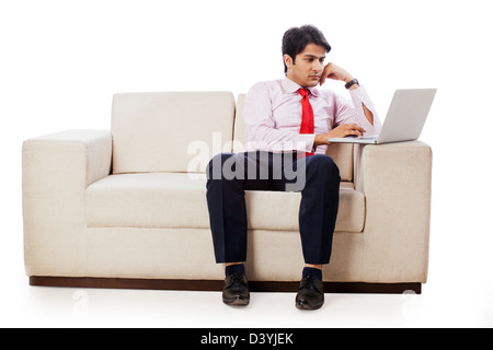 Geschäftsmann auf einer Couch sitzen und arbeiten auf einem laptop Stockfoto
