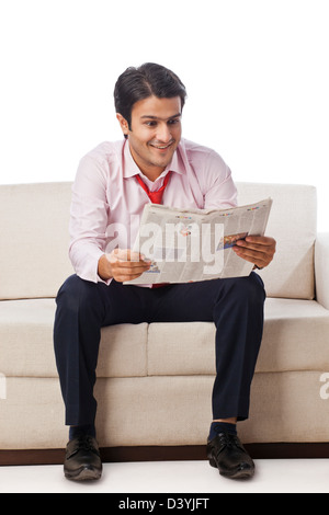 Geschäftsmann auf einer Couch sitzen und eine Zeitung lesen Stockfoto
