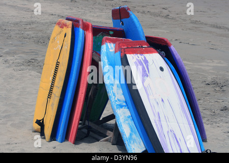 Gestapelte Body-Boards oder Boogie Boards auf einem überdachten Sandstrand an der Küste des Pazifischen Ozeans in Tonsupa, Ecuador Stockfoto