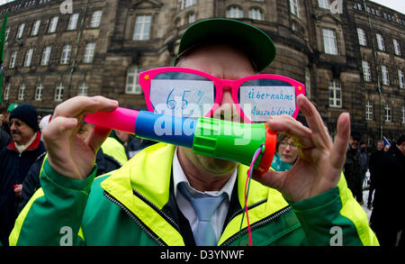 Dresden, Deutschland. 26. Februar 2013. Polizisten Torsten Scheller trägt ein paar riesige Gläser die lautet: "6.5. Prozent "(L) und"Übernahme von Auszubildenden"während einer Demonstration vor der sächsischen Staatskanzlei in Dresden. Deutsche Dienstleistungsgewerkschaft Verdi, sowie der Polizei Union BIP und des Lehrers Union GEW aufgerufen Proteste aufmerksam auf die Anforderungen für neue Tarife auf die Gehälter für Mitarbeiter im öffentlichen Dienst. Foto: Arno Burgi/Dpa/Alamy Live-Nachrichten Stockfoto