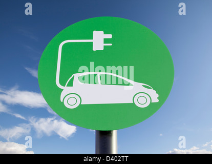 Grünes Schild eine Ladestation für Elektrofahrzeuge, sonniger blauer Himmel in der Postproduktion hinzugefügt Stockfoto