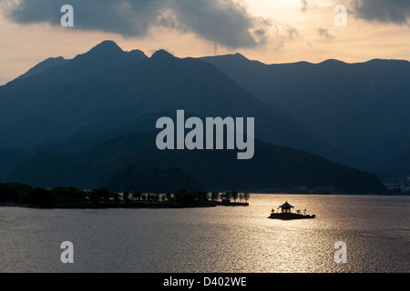 Sonnenuntergang Silhouette der Insel Schrein auf Kawaguchi-See mit den Bergen im Hintergrund. Stockfoto