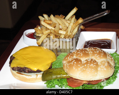 Rindfleisch-Hamburger und Pommes Frites mit Gurke, gelber Käse und Tomaten Stockfoto