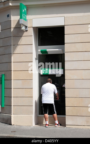 Mann mit ein Geldautomat in der BNP Paribas-Filiale in Compiègne, Oise Abteilung der Picardie, Nord-Frankreich. Stockfoto