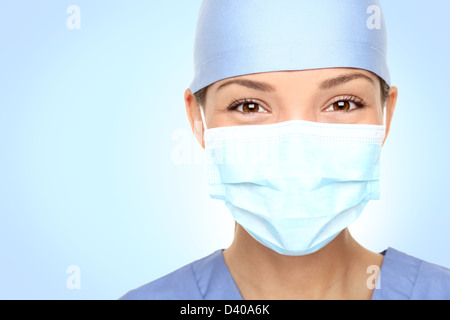 Closeup Portrait der jungen asiatischen kaukasischen Frauen Arzt / medizinisches Personal lächelnd hinter Chirurg Maske Stockfoto