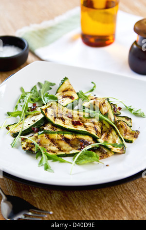 Gegrillte Zucchini mit getrockneten Chili-Flocken, Rucola und Minze-Salat Stockfoto