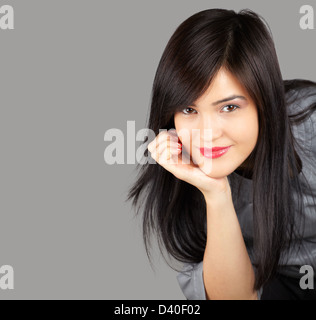 Porträt einer hübschen jungen Frau auf einem grauen Hintergrund Stockfoto