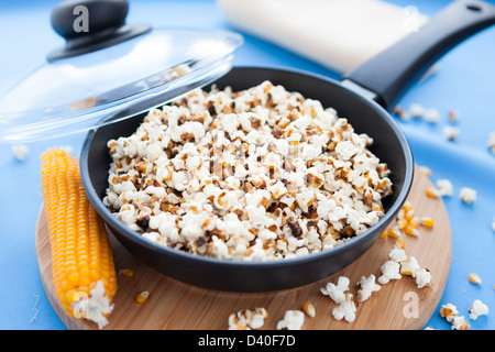 Popcorn in einem Topf auf einem blauen Hintergrund, Nahaufnahme Stockfoto