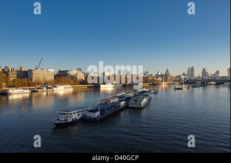 Themse-Blick nach Osten von Waterloo Bridge bei Sonnenaufgang mit Booten im Vordergrund Stockfoto