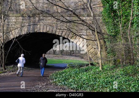 Zwei Frauen gehen unter einer Brücke über den Fluss Kelvin trägt den Forth und Clyde Kanal. Stockfoto