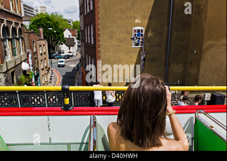 Der Hanging man Banksy Graffiti-Kunst auf Park Street, Bristol, UK, betrachtet von an Bord ein Bristol City Sightseeing Tourbus. Stockfoto