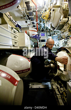 Mann der Besatzung mit Hand am Hebel im Torpedo Raum des nuklearen u-Boot HMS Talent Stockfoto