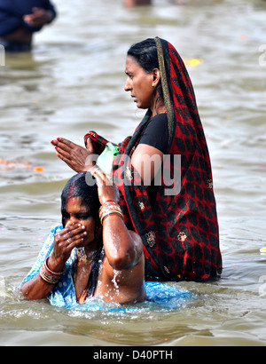 Frauen-Anhänger versammelt, um am Ufer der Sangam Zusammenfluss des Flusses Ganga, Yamnuna und mythischen Saraswati ein heiliges Bad zu nehmen. Stockfoto