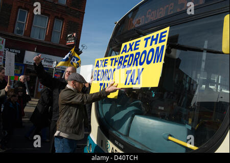 Bootle, UK. 28. Februar 2013. Mann hält "Axt die Schlafzimmer-Steuer"-Zeichen vor der Bus. Stand Up In Bootle, eine Basisgruppe Kampagne in der Nähe von Liverpool organisiert eine Demonstration in Bootle Innenstadt gegen die Schlafzimmer-Steuer. Polizeilichen Schätzungen über die Demonstration am 1200 Credit: David Colbran / Alamy Live News Stockfoto