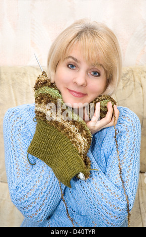 Die Frau in einem blauen Pullover strickt Stockfoto