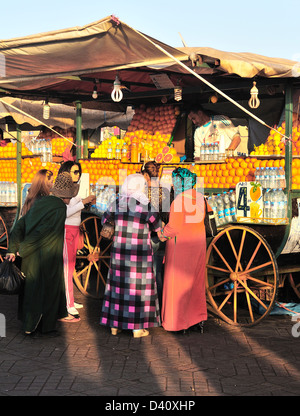 Einheimischen vor einem Orangensaft-Verkäufer in Jemaa El Fna, Marrakesch (Marrakech), Marokko Stockfoto