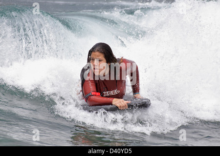 Weibliche Boogie Boarder auf einer Welle aus Kapahulu Leiste-Waikiki Beach, Honolulu, Oahu, USA. Stockfoto