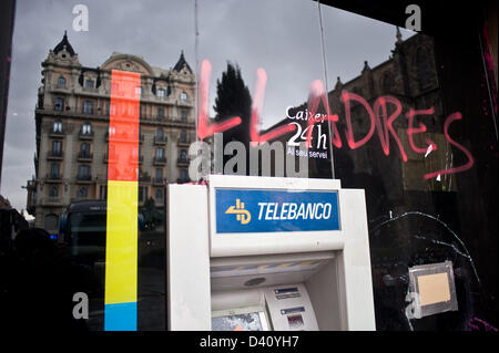 28 Februar, 2013-Barcelona, Spain.The Wort "Lladres" (Diebe in katalanischer Sprache) an der Fassade einer Bank während einer Studentendemonstration geschrieben. Der katalanische Student-Sektor ist streiken aus Protest gegen die Kürzungen der Regierung gegen die Universität und die Aufklärung der Öffentlichkeit. Am Ende der Demonstration wurden Zusammenstöße mit der Polizei und Angriffe auf Banken. Stockfoto