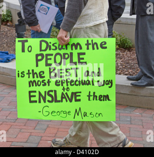 Ein Mann trägt ein Schild, dass Amerikaner entwaffnen ist es, ihnen bei einer Kundgebung in Asheville, NC am 23. Februar 2013 versklaven Stockfoto