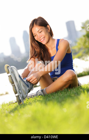 Glückliche junge Frau auf Inline-Skates für Inline-Skating mit Montreal Stadt Skyline im Hintergrund Stockfoto