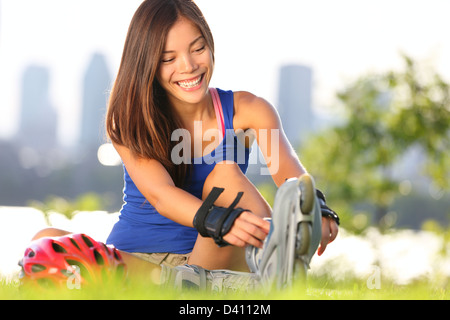 Glückliche junge Frau auf Inline-Skates für Inline-Skating mit Montreal Stadt Skyline im Hintergrund Stockfoto