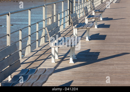 Hölzerne Bänke Zeile am River Embankment. Horizontalen Schuss Stockfoto