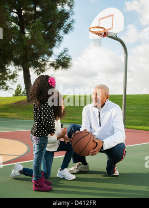 Basketball spielen mit Enkelinnen Mann Stockfoto