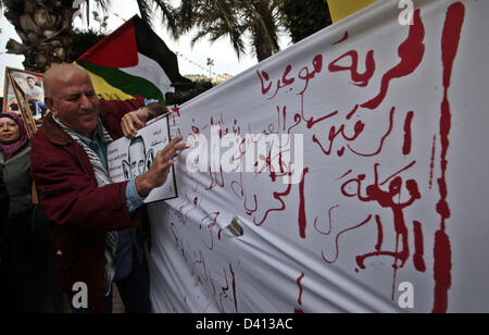 25. Februar 2013 - Nablus, West Bank, Palästina - Palästinenser schreiben Briefe im Blut auf ein Banner während einer Demonstration zur Unterstützung der palästinensischen Häftlinge in israelischen Gefängnissen. Proteste zur Unterstützung der palästinensischen Häftlinge im Hungerstreik in israelischen Gefängnissen wurden Gebäude und neuen Schwung mit dem plötzlichen Tod in seiner Zelle auf 23. Februar, der 30-Jahr-alten Arafat Jaradat, eine ehemalige militante palästinensische Präsident Mahmud Abbas Fatah-Bewegung.  (Kredit-Bild: © Nedal Eshtayah/APA-Images/ZUMAPRESS.com) Stockfoto