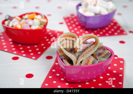 Drei Liebe herzförmige Schalen mit verschiedenen Süßspeisen in ihnen in einer Kinder-Party einstellen Stockfoto